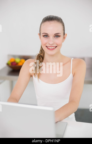 Cheerful young woman using her laptop Stock Photo