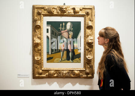London, UK - 14 January 2014: a member of staff of the Estorick Collection of Modern Italian Art looks at a canvas entitled “Il Trovatore, 1955“ at the Giorgio de Chirico: Myth and Mystery exhibition that opens tomorrow and runs until the 19 April 2014. Credit:  Piero Cruciatti/Alamy Live News