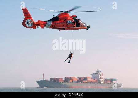 US Coast Guard Petty Officer 3rd Class Andrew Wilson, a rescue swimmer with Air Station Houston dangles above Galveston Bay during training January 9, 2014 in Galveston, Texas. Stock Photo