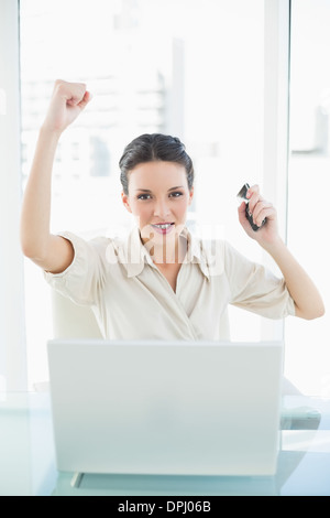Assertive stylish brunette businesswoman raising her fist Stock Photo