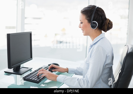 Smiling stylish brunette operator using a computer Stock Photo