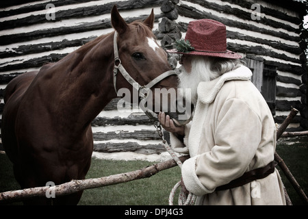 Western cowboy Santa spending time with his trusty steed Stock Photo