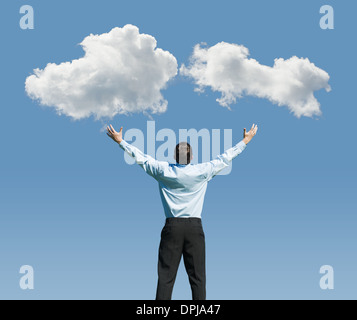 beautiful clouds and happy young man with his hands up.Concept image on cloud computing and rest Stock Photo