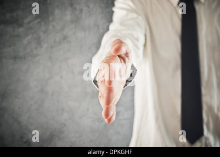 Businessman offering hand for a handshake, selective focus. Business communication, introduction or agreement concept. Stock Photo