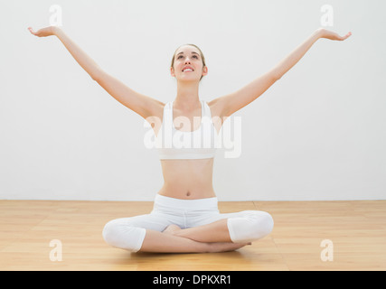 Peaceful young woman sitting in lotus position on floor Stock Photo