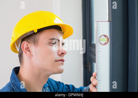 Young handyman using a spirit level Stock Photo