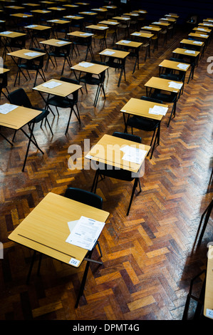 Rows lines of empty desks ready for Welsh [WJEC] GCSE school pupils sitting exams in a school hall, Wales UK Stock Photo