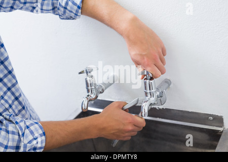 Close up of a plumber's hand and washbasin Stock Photo