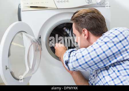 Technician repairing a washing machine Stock Photo