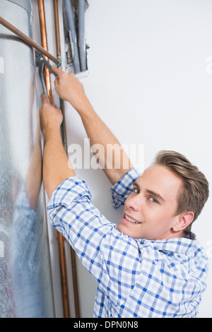 Technician servicing an hot water heater' pipes Stock Photo