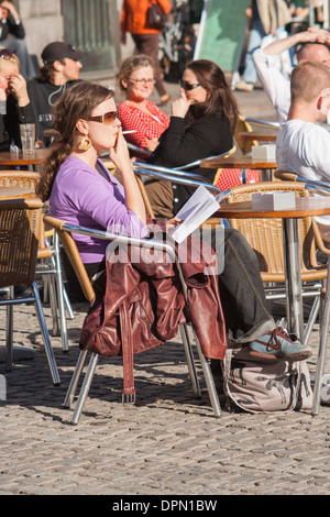 Young woman smoking in a city center cafe, Copenhagen, Denmark Stock Photo