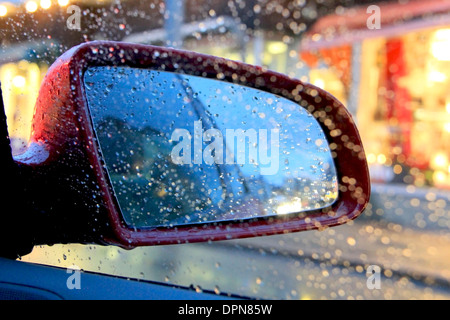 Abstract image of rain drops on car side view mirror and window. Stock Photo