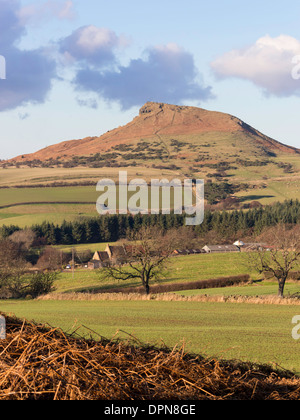 Roseberry Topping in the Cleveland Hills viewed from Gribdale with many people climbing on a sunny winter's day Stock Photo