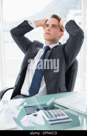 Worried young businessman at office desk Stock Photo