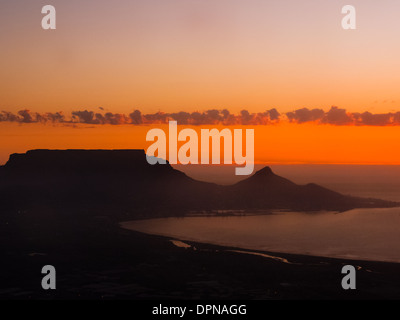Aerial view of sunrise over Cape Town South Africa showing silhouette of surrounding mountains and coastline Stock Photo