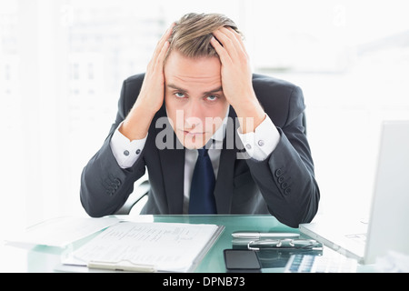 Worried businessman sitting at office desk Stock Photo