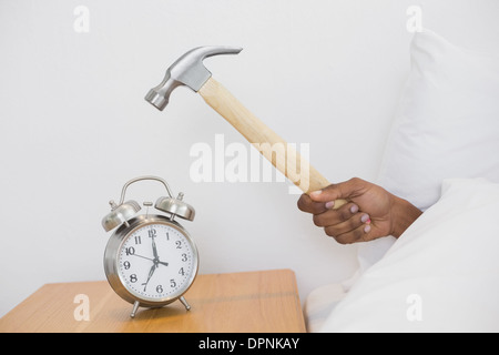 Smashing alarm clock with hammer Stock Photo