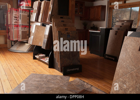 A display area in a design center shows a variety of floor coverings.  Model kitchen in background. Stock Photo