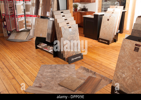 A display area in a design center shows a variety of floor coverings.  Model kitchen in background. Stock Photo