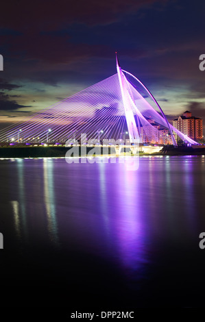 Seri wawasan bridge under purple illumination reflected in water, Putrajaya, Malaysia Stock Photo