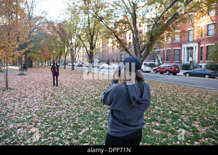 A woman poses for her photographer friend in a park in Boston. Stock Photo