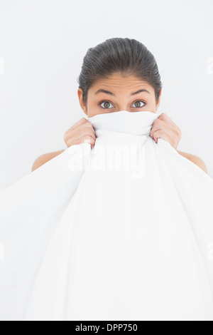 Portrait of a woman covering face with bedsheet Stock Photo