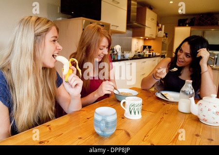 Three teenage girls young women having breakfast and talking, Essex UK Stock Photo