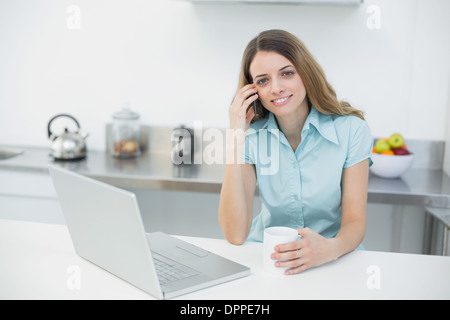 Attractive young woman posing in her kitchen smiling at camera Stock Photo