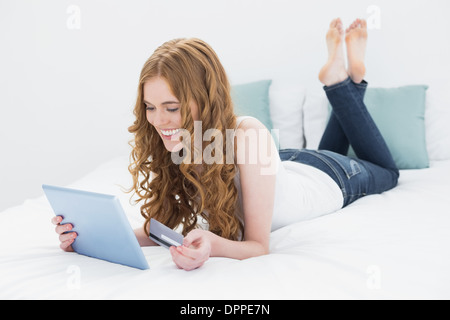 Casual young blond doing online shopping in bed Stock Photo