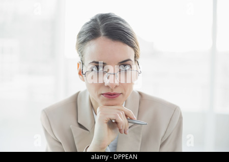 Young gorgeous businesswoman wearing glasses looking at camera Stock Photo