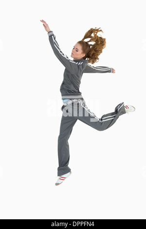 Full length side view of a sporty young blond jumping Stock Photo