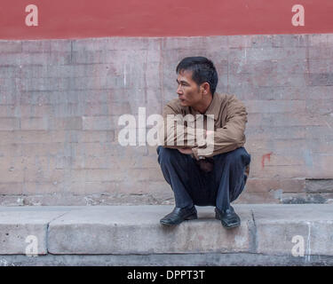 Beijing, China. 26th Oct, 2006. In a squatting pose common in China, a man rests on a walkway in Beijing, capital of the Peoples Republic of China. © Arnold Drapkin/ZUMAPRESS.com/Alamy Live News Stock Photo