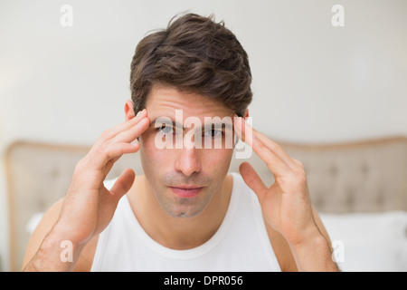Close up of man suffering from headache in bed Stock Photo