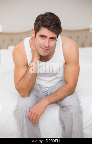 Portrait of man suffering from neck ache in bed Stock Photo