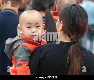 Beijing, China. 26th Oct, 2006. A young Chinese boy peeks over the shoulder of his mother in Beijing, capital of the Peoples Republic of China. © Arnold Drapkin/ZUMAPRESS.com/Alamy Live News Stock Photo