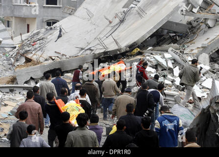 Jan 17, 2009 - Beit Lahiya, Gaza Strip - Palestinian mourners walk amidst debris of destroyed buildings carrying the bodies of victims of Israeli bombardments during their funeral procession in Beit Lahia, northern Gaza Strip. Israel battered Gaza with new strikes today, as it was poised to unilaterally halt a 22-day-old war on Hamas that has killed nearly 1,200 Palestinians and le Stock Photo