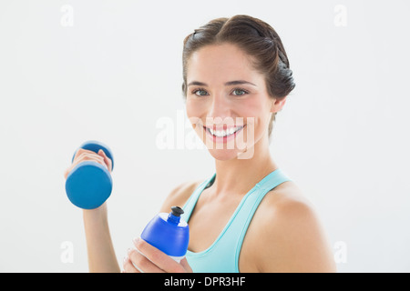 Woman with dumbbells and water bottle over white background Stock Photo