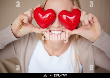 Image of smiling female with two red hearts by her eyes Stock Photo
