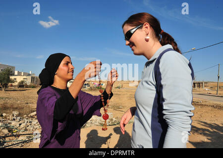 Nov 25, 2008 - Rahat, israel - Woman gives necklace. In Israel, tens of thousands of Arab Bedouin fear that the Israeli government wants to seize land they say belongs to them and to put an end to their traditional nomadic lifestyle. The Israeli Arab Bedouin are 160,000 Israeli citizens, who live in what are called 'unrecognized villages' that don't appear on any maps and don't get Stock Photo