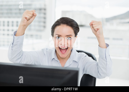 Portrait of an excited businesswoman clenching fists in office Stock Photo