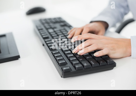Hands typing on a keyboard in an office Stock Photo