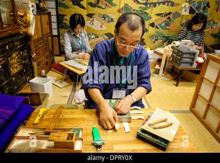 Skilled Japanese craftsman prepares layers of gold ready to make gold leaf, an old Japanese tradition. Kinpaku Kanazawa Japan Craftsman craft Stock Photo