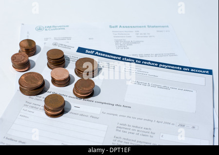 Piles of pennies and coins on a self-assessment  HM Revenue and Customs tax form Stock Photo