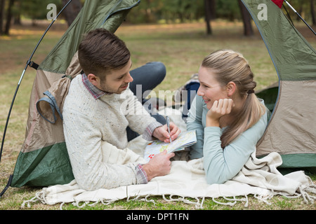 Couple with a map lying in tent Stock Photo