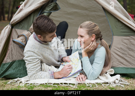 Young couple lying in tent with a map Stock Photo