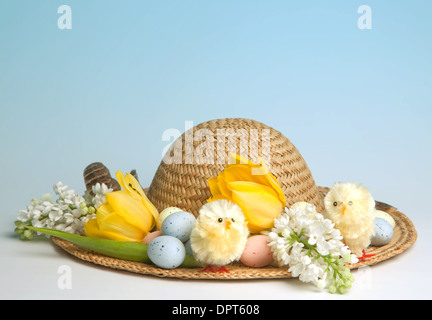 Straw hat decorated for easter with flowers, chicks and easter eggs Stock Photo