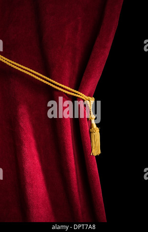 Red velvet curtain with tassel. Close up black isolated curtain Stock Photo