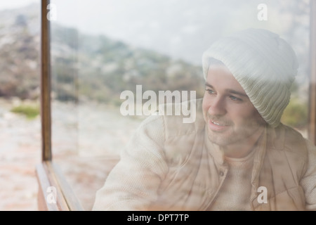 Thoughtful man looking out through window Stock Photo