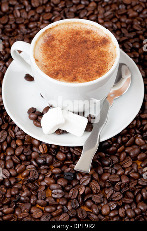 Cup of fresh coffee surrounded by coffee beans Stock Photo