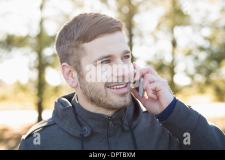 Close up of a smiling man using cellphone outdoors Stock Photo